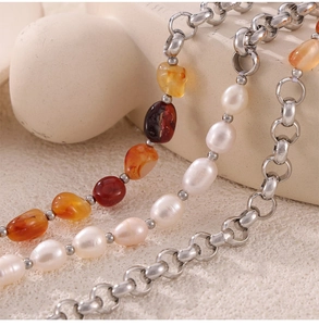 Macro shot of 18k gold plated chain with natural amber stones and freshwater pearls
