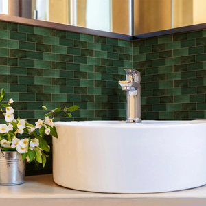 Detail of dark green matte tile stickers used as a waterproof backsplash in a modern bathroom