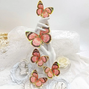Détail de stickers muraux papillon 3D roses avec bords dorés sur fond de dentelle