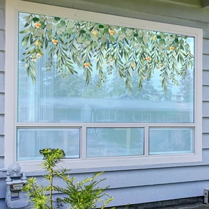 Detail of static window film showing realistic green hanging vines with yellow flowers