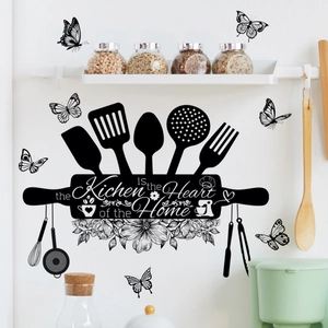 Detail of black kitchen wall decal featuring cutlery silhouettes and heart of the home quote