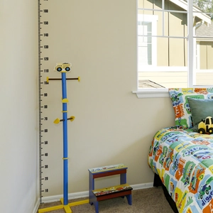 Kids height measurement chart with blue metal stand and cartoon engineering truck theme