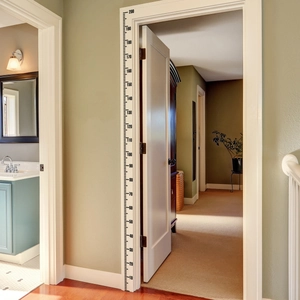 Detail of minimalist height growth chart sticker measuring 10-200cm on white door frame