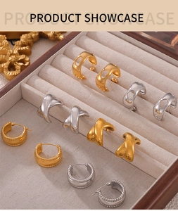 Collection de boucles d'oreilles géométriques dorées et argentées sur présentoir en lin