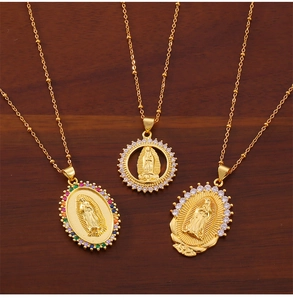 Detailed close-up of Virgin Mary gold pendants with colorful cubic zirconia on wood