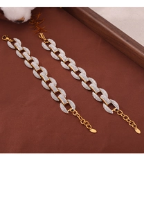Detalle de pulseras de cadena de oro y plata con circones pavimentados en fondo cálido