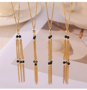 Detail view of four gold-plated tassel necklaces with black agate beads and fine chains