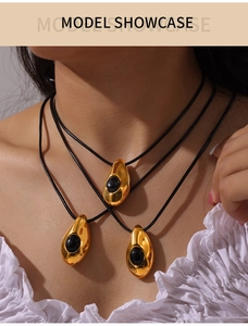 Gros plan du collier goutte plaqué or 18k avec agate noire porté par un mannequin