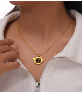 Detail shot of a gold titanium steel necklace featuring a vintage natural tiger eye stone