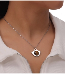 Detail of tiger eye stone pendant on titanium steel chain worn by a model