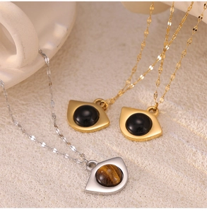 Macro detail of titanium necklaces with natural tiger eye and onyx in fishtail chain links