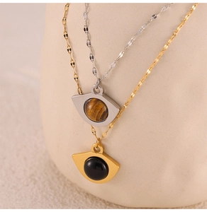 Close-up of vintage titanium steel necklaces with natural tiger eye and black stone
