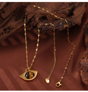 Close-up of golden titanium necklace with tiger eye stone eye-shaped pendant details