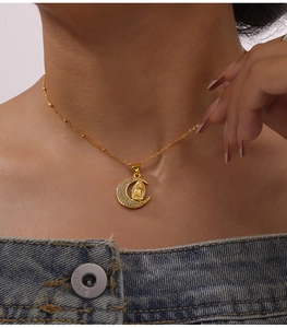 Close-up of gold moon pendant with Virgin Mary relief and sparkling white zircons