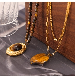 Détail de pendentifs œil-de-tigre ovales avec perles dorées vintage et chaînes
