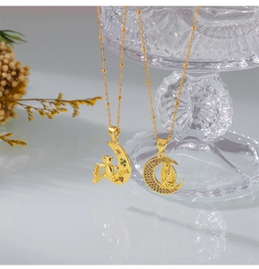 Detail of gold moon pendants with LOVE bear and religious icon on crystal glass