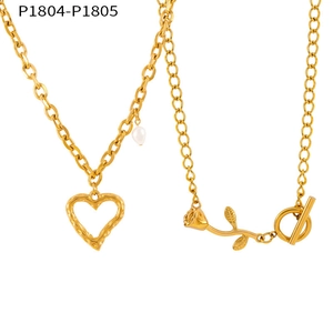 Detalle de colgante de corazón dorado con perla y dije de rosa en cadena de aro