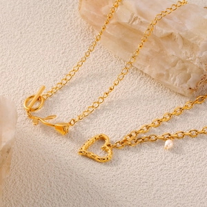 Collar bañado en oro con corazón, rosa y perla blanca con cierre OT sobre fondo mineral