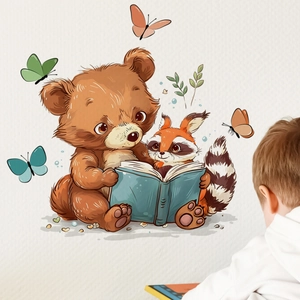 Detail of cartoon bear and raccoon reading book wall sticker in a cozy nursery room