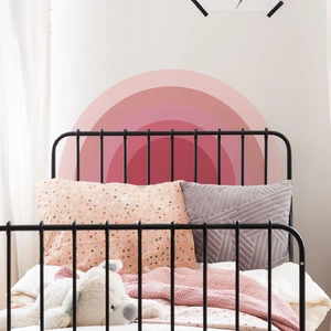 Detail of pink gradient bohemian rainbow wall sticker in a cozy nursery room setting