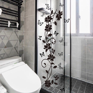 Detail of black floral and butterfly vinyl wall stickers on modern bathroom glass