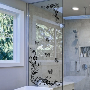 Detail of black floral and butterfly self-adhesive vinyl wall stickers on a bathroom glass door