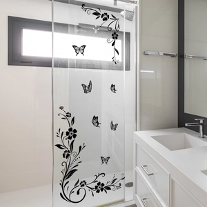Detailed view of black floral and butterfly decals applied on a clear glass shower door