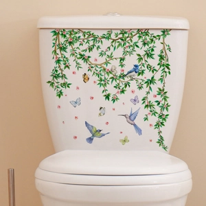 Detail of colorful birds and floral wall stickers applied on a white ceramic toilet tank
