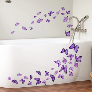 Détail de stickers papillons violets sur une baignoire blanche pour décor de salle de bain