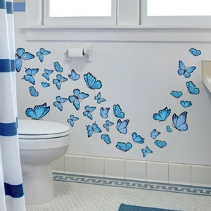 Vue détaillée de stickers muraux papillons bleus avec dégradé sur carrelage de salle de bain