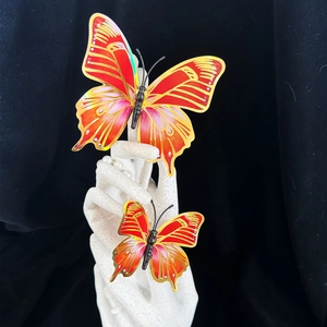 Detail of 3D orange butterfly wall stickers with gold edges on white display hand