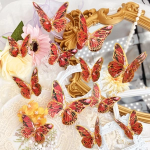 Detail of red and gold 3D butterfly wall stickers with intricate layered wing textures