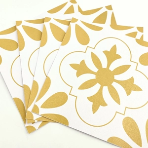 Detail of four square mandala tile stickers with gold floral pattern on white background