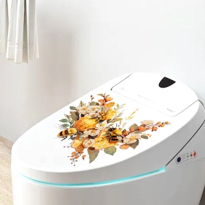 Dettaglio di adesivi con api e fiori arancioni su un copriwater bianco per il bagno