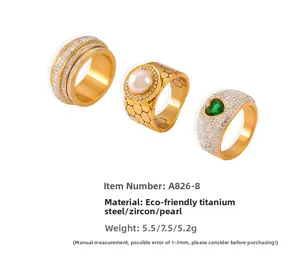 Detalle de anillos de acero de titanio dorado con circonitas y perlas de concha