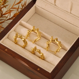 Boucles d'oreilles créoles dorées irrégulières en C dans un coffret de luxe
