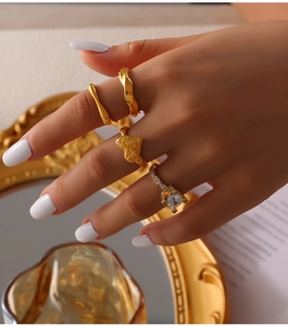 Detail of four vintage French gold rings featuring zircon stones and heart relief design