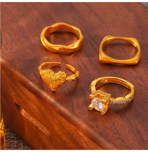Close-up of four-piece vintage gold-plated rings set with zircon inlay on wood surface