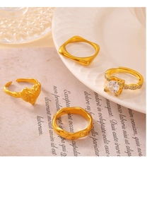 Detail of four vintage 18k gold plated titanium rings with zircon and geometric patterns