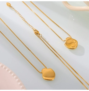 Close-up van onregelmatige 18K vergulde titanium hanger aan een vierkante ketting