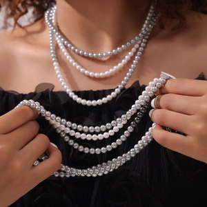 Ensemble de colliers de perles multicouches élégants en blanc et gris sur modèle