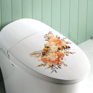 Dettaglio adesivo floreale con api e fiori arancioni su un copriwater bianco lucido