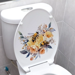 Dettaglio macro di adesivi con api e fiori applicati su un sedile del water bianco lucido