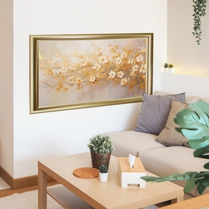 Modern gold floral wall art with metallic frame above a cozy living room sofa decor