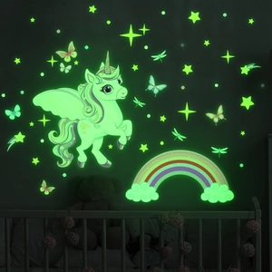 Luminous unicorn and rainbow wall stickers glowing in a dark kids room setting