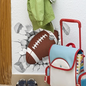 Détail d'un sticker mural de football 3D avec effet de mur brisé pour chambre d'enfant