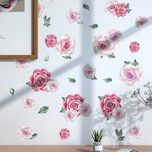 Détail de stickers muraux roses aquarelles et feuilles vertes sur un mur de chambre