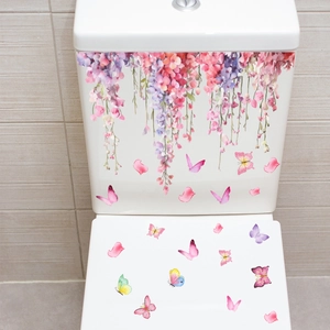 Detail of pink floral vines and colorful butterflies on white ceramic toilet lid