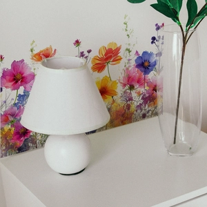 Detail of a minimalist white table lamp with spherical base in a cozy home setting
