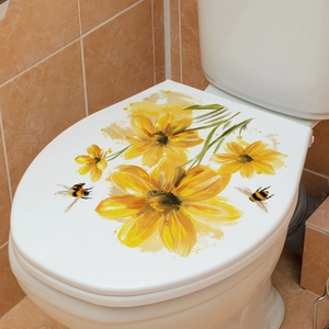 Close-up of yellow flower and bee decals applied on a white toilet lid in a bathroom